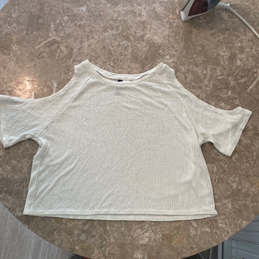 White t-shirt with cutout shoulders. Sweater material with ribbed pattern.